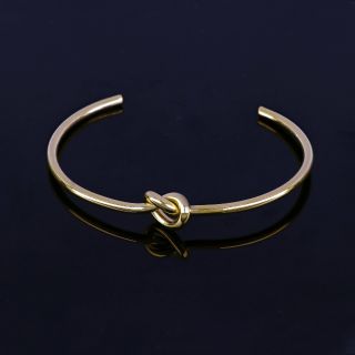 Stainless steel gold plated bangle with knot - 